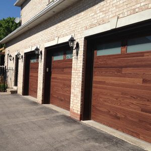 Modern Woodgrain Garage Doors with Frosted Windows Installed by Giant Doors