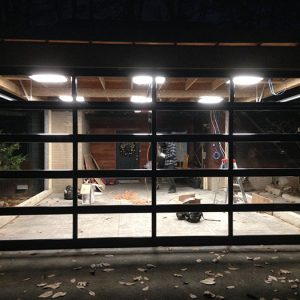 Oversized Aluminum Clear Glass Garage Door DUring The Installation in Custom Home in Oakville by Modern Doors